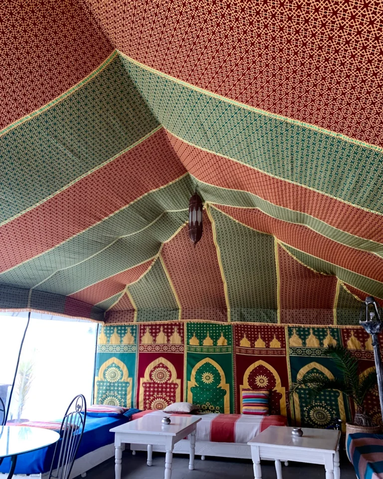 Innenansicht eines marokkanischen Berberzeltes im Riad Dar Nafal mit bunten Stoffen und traditionellen Laternen.