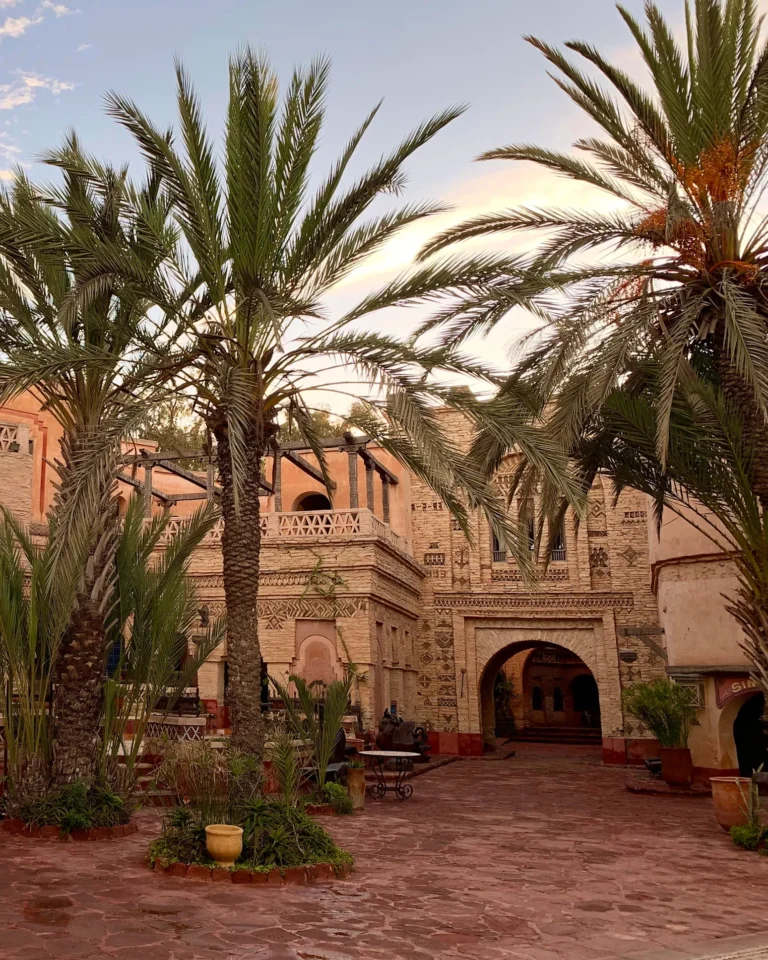 Palmen und traditionelle Mauern im Innenhof der Medina d'Agadir.
