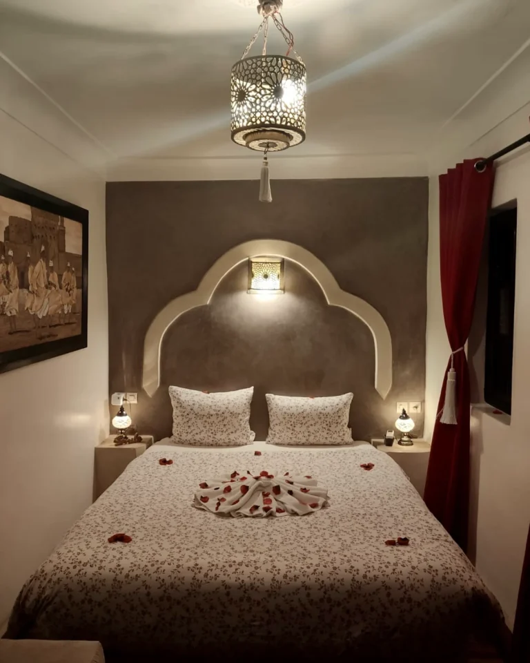 Hergerichtetes Schlafzimmer im Riad M'Boja Chez Ali Baba in Marrakesch mit Handtuch-Schwänen auf dem Bett.