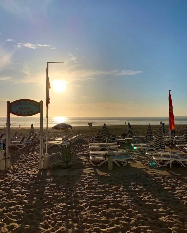 Strand Agadir mit leeren Liegen bei Sonnenuntergang.