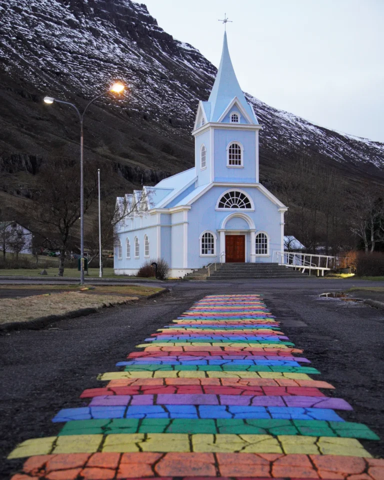 The vibrant and colorful church in Seyðisfjörður, Iceland, standing proudly against the fjord