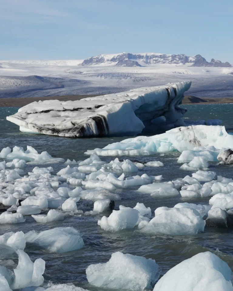 Small ice chunks floating in the water at Diamond Beach, with Vatnajökull Glacier visible in the background, Iceland