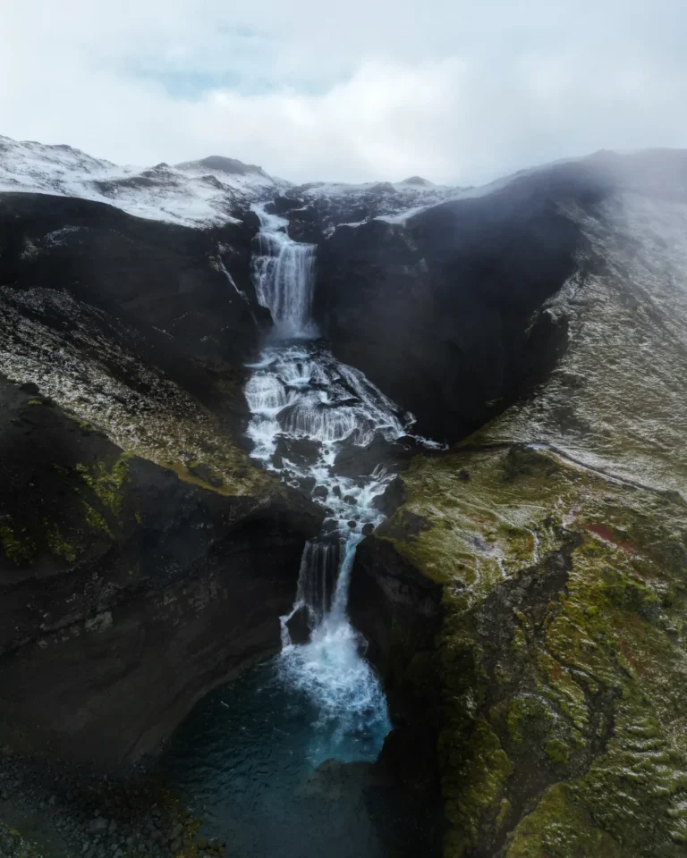 Aerial view of Ófærufoss waterfall cascading in Eldgjá Canyon, surrounded by vibrant green grass, Iceland