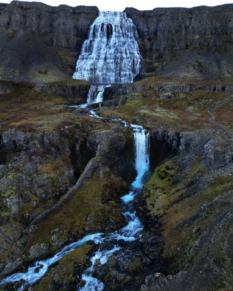 A breathtaking drone view of Dynjandi Waterfall in Iceland, cascading over rugged cliffs