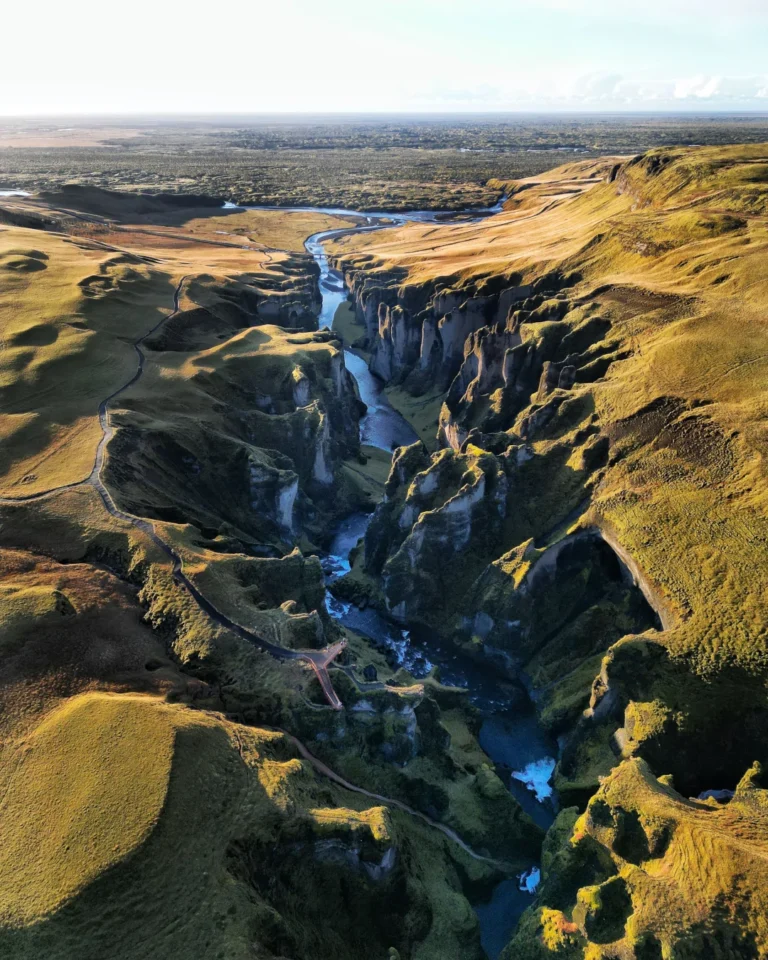 Overlooking Fjaðrárgljúfur Canyon, showcasing the lush green valley and winding river, Iceland