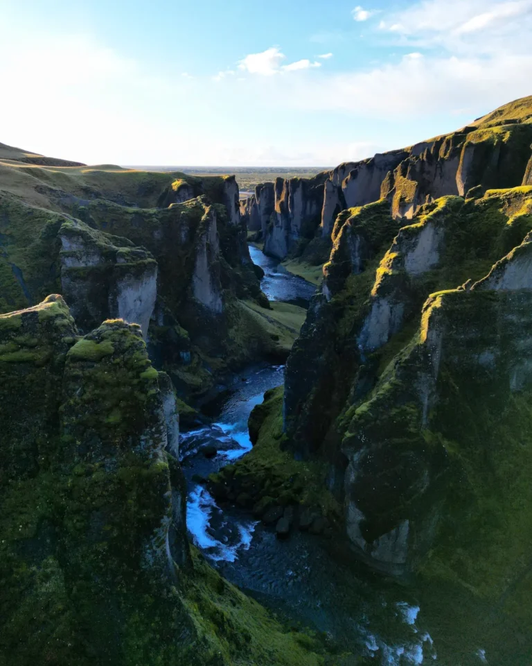 Majestic view of Fjaðrárgljúfur Canyon with winding river and lush green cliffs, Iceland