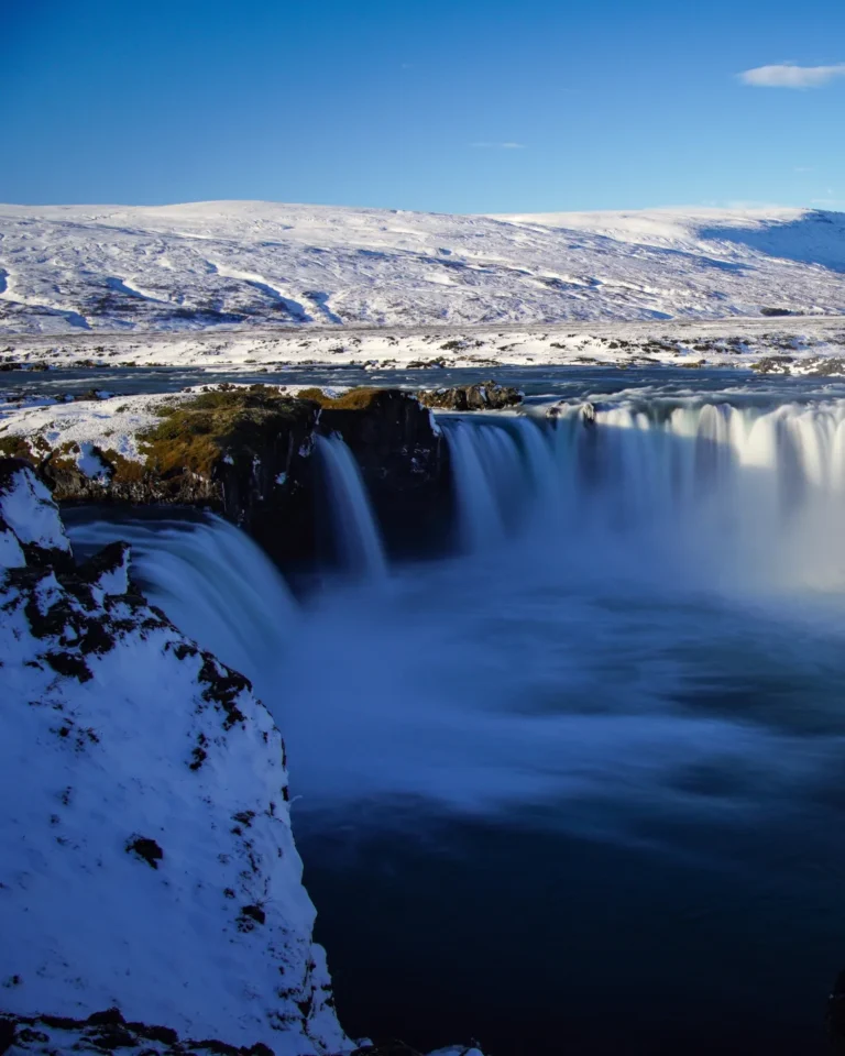 The left section of Goðafoss waterfall in Iceland, framed by rugged cliffs and flowing water