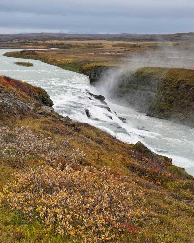 Gullfoss waterfall in autumn, surrounded by brown grass and light mist, Iceland