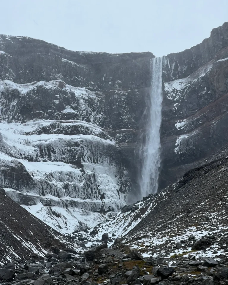 Hengifoss waterfall surrounded by snow, with no visible red layers, Iceland