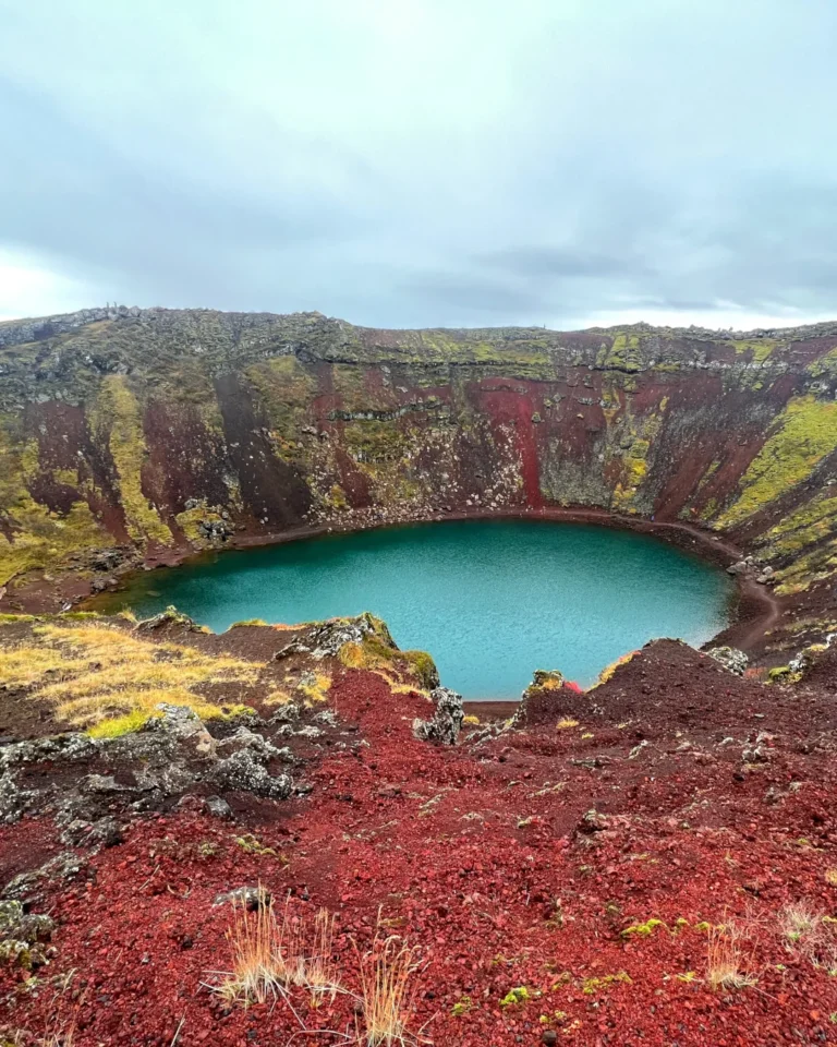 Kerid volcanic crater with striking red slopes and a vivid blue lake in Iceland