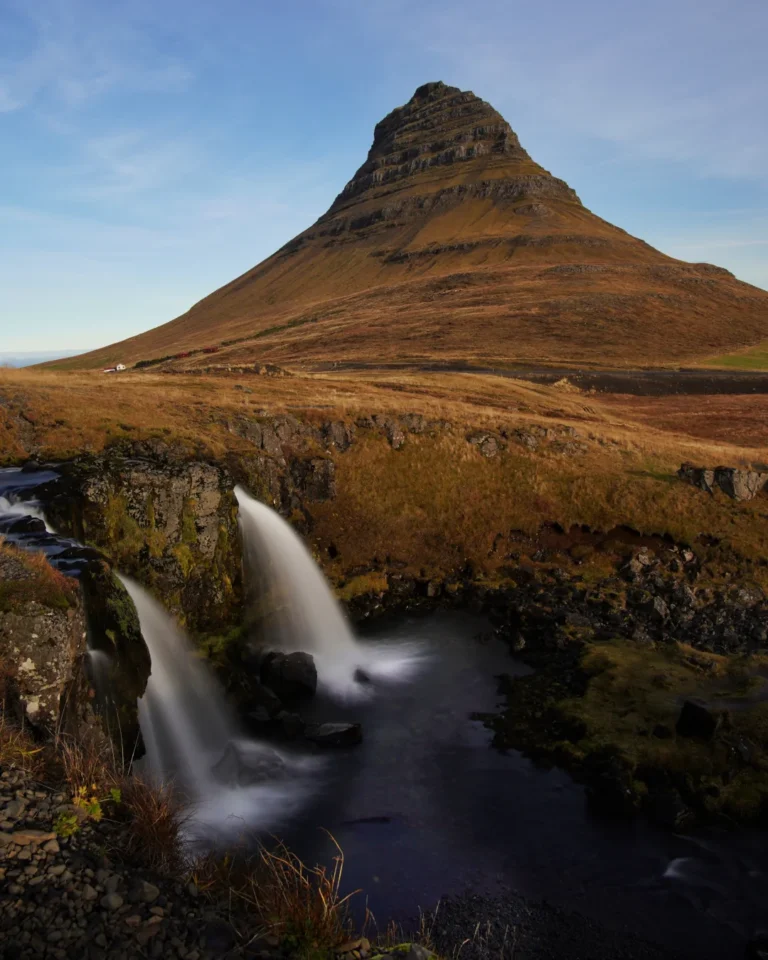 Kirkjufell Waterfall in Iceland, with the iconic Kirkjufell Mountain under a clear blue sky