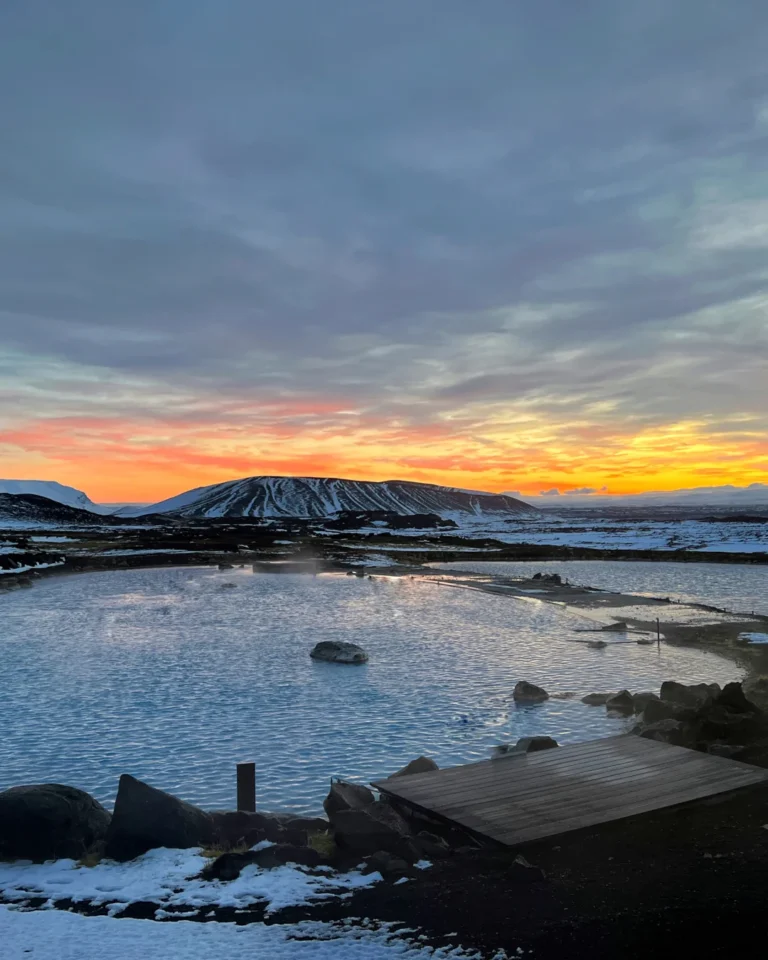 A beautiful sunset over the Mývatn Nature Bath, with the warm geothermal waters glowing under the evening sky