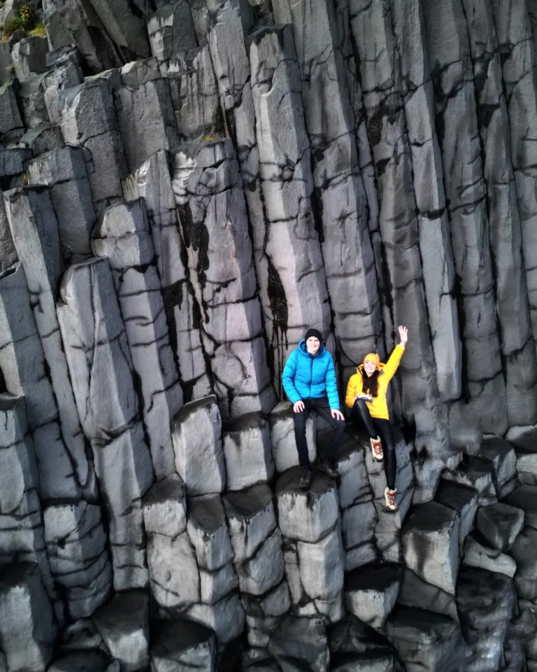 Drone shot of us sitting on top of the iconic basalt columns at Reynisfjara Black Sand Beach, Iceland