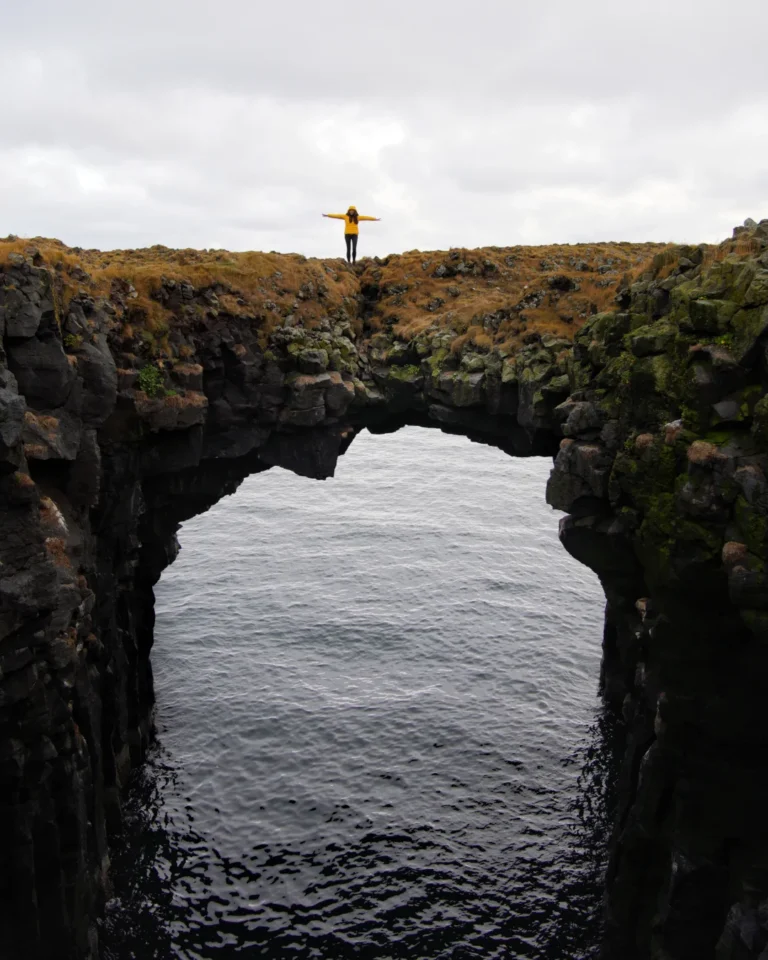 A person walking across a natural cliff bow on the Snæfellsnes Peninsula in Iceland