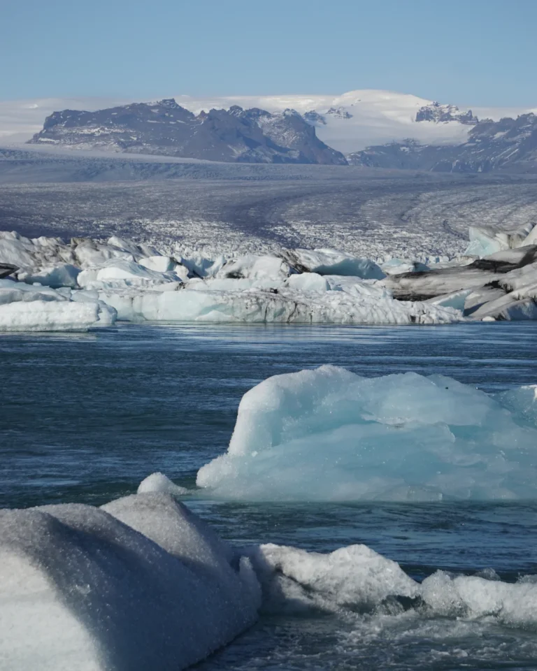 An ice block floating in Vatnajökull Lake, with the Vatnajökull Glacier in the background, Iceland