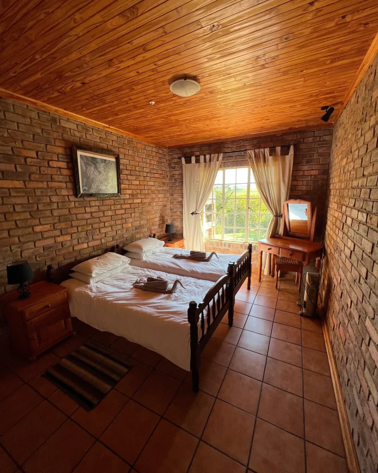 Bedroom in a Graskop Airbnb with towels folded into swans in South African style.