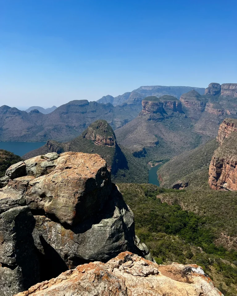 View from the top into the Blyde River Canyon with blue water and striking brown rocks.