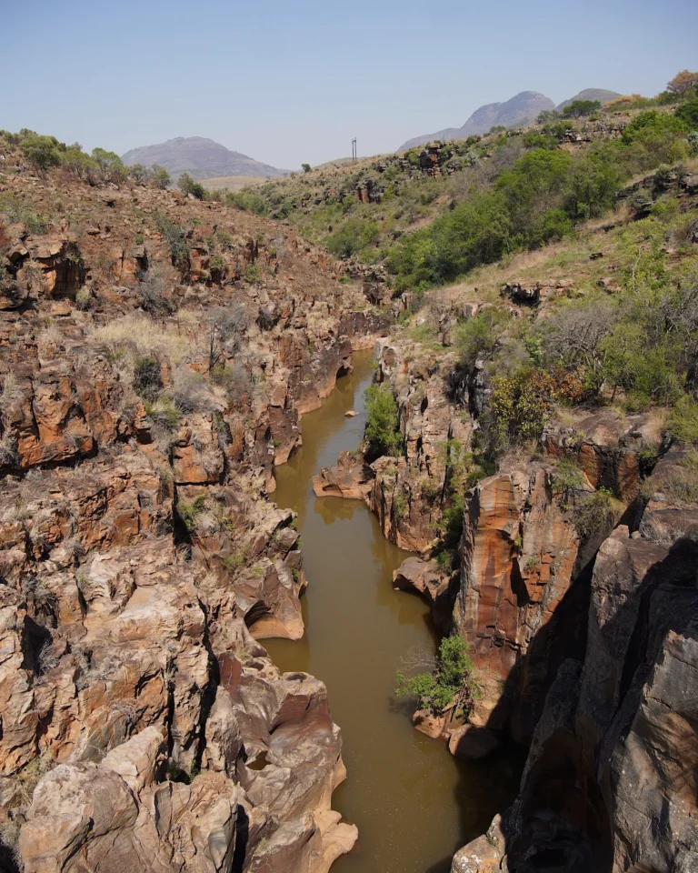 Brown river winding through the rock formations of Bourke's Luck Potholes.