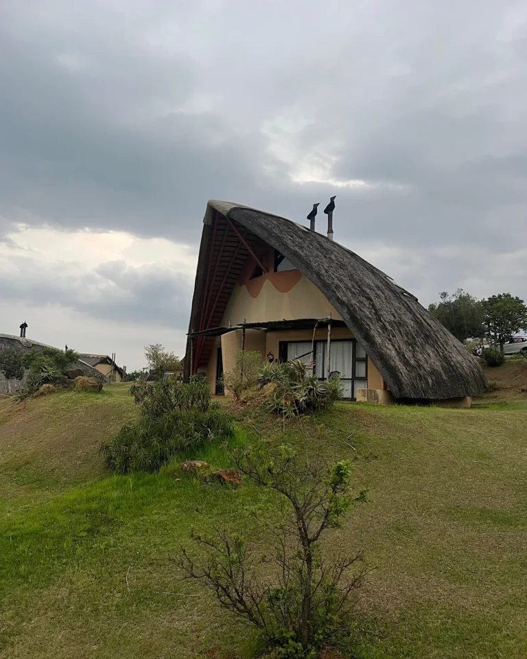 Front view of the accommodation at Didima Camp with terrace and thatched roof near Cathedral Peak.