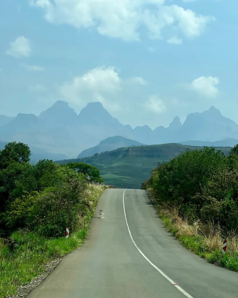 Road to the entrance of Royal Natal National Park with the large Drakensberg mountains in the background.