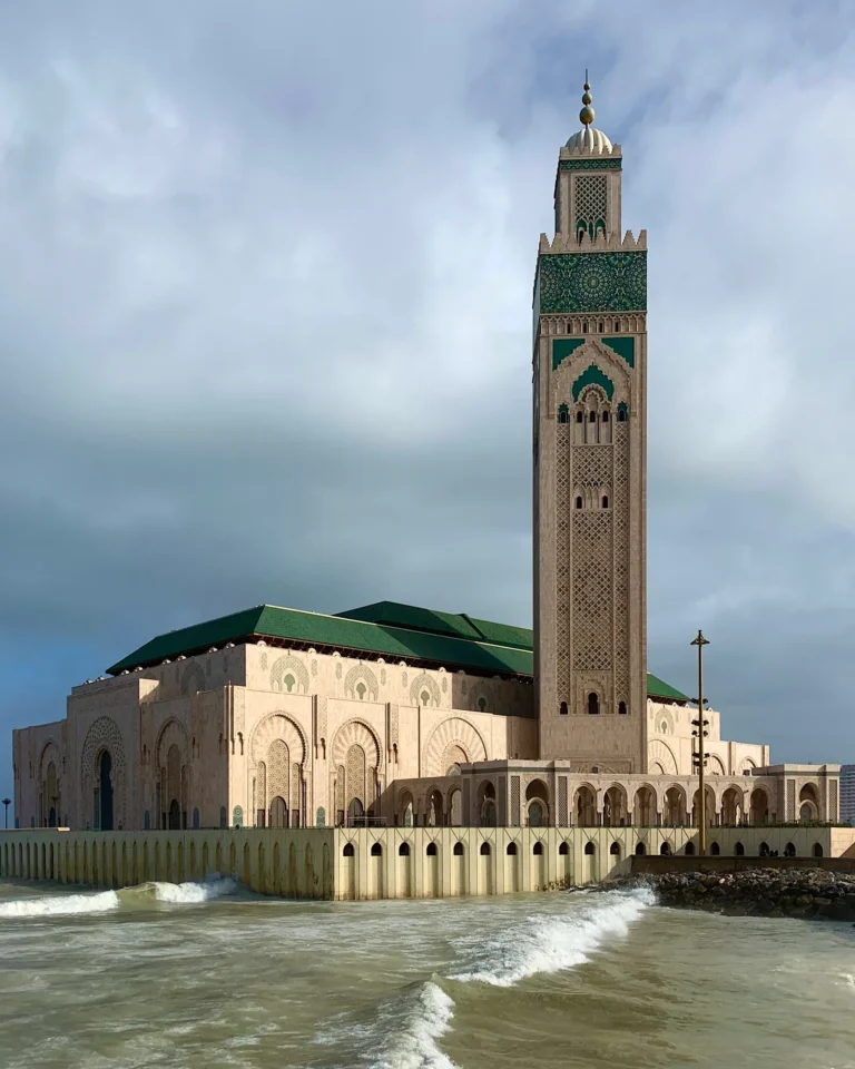 Close-up of the Hassan II Mosque in Casablanca with the Atlantic Ocean in the foreground.