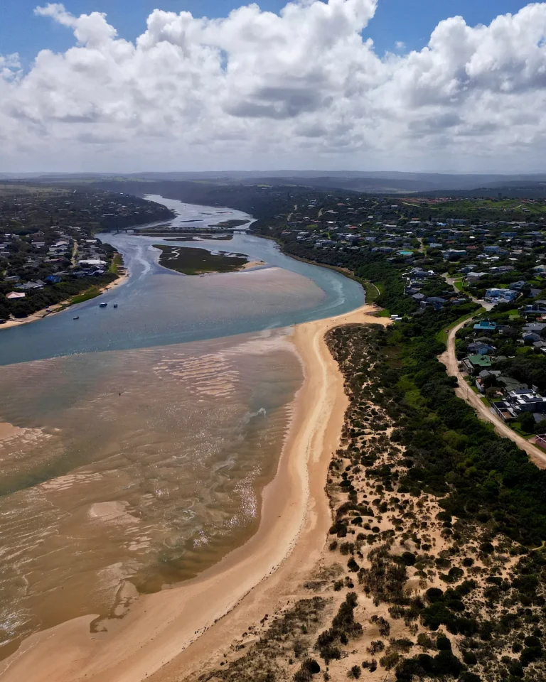 Drone shot of Kenton-on-Sea showing a blue river with islands and the town.
