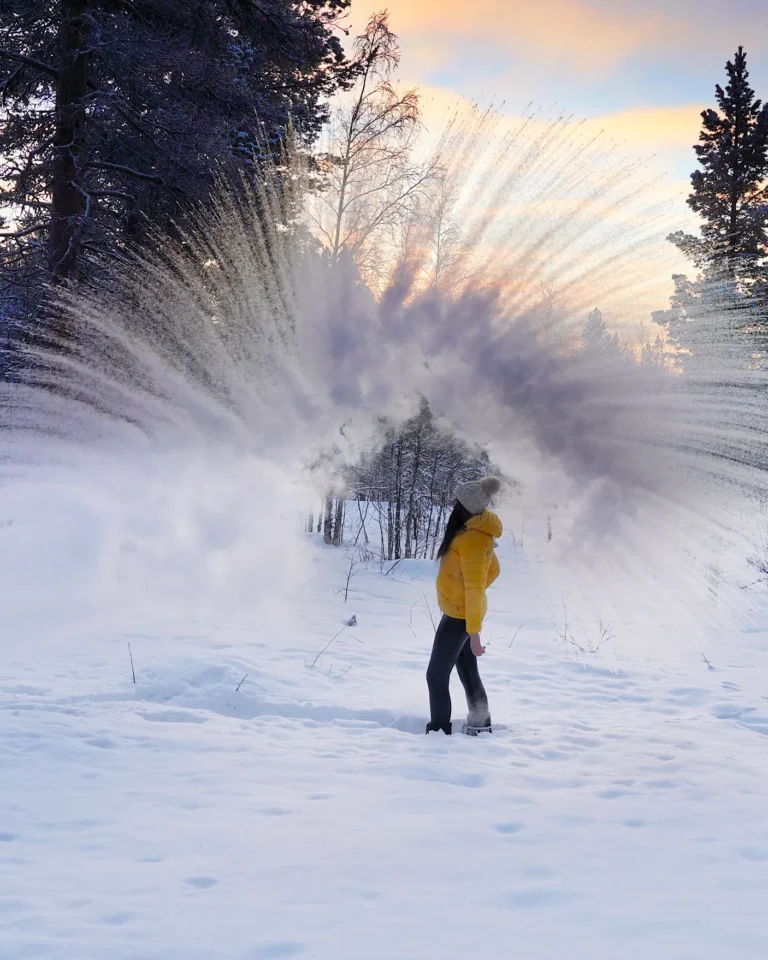 A person throwing boiling water into the air at minus 28 degrees, instantly turning into ice crystals.