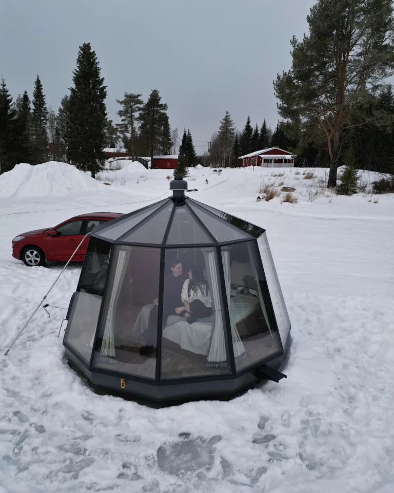 Drone shot of a snowy glass igloo in the winter landscape of Rovaniemi.