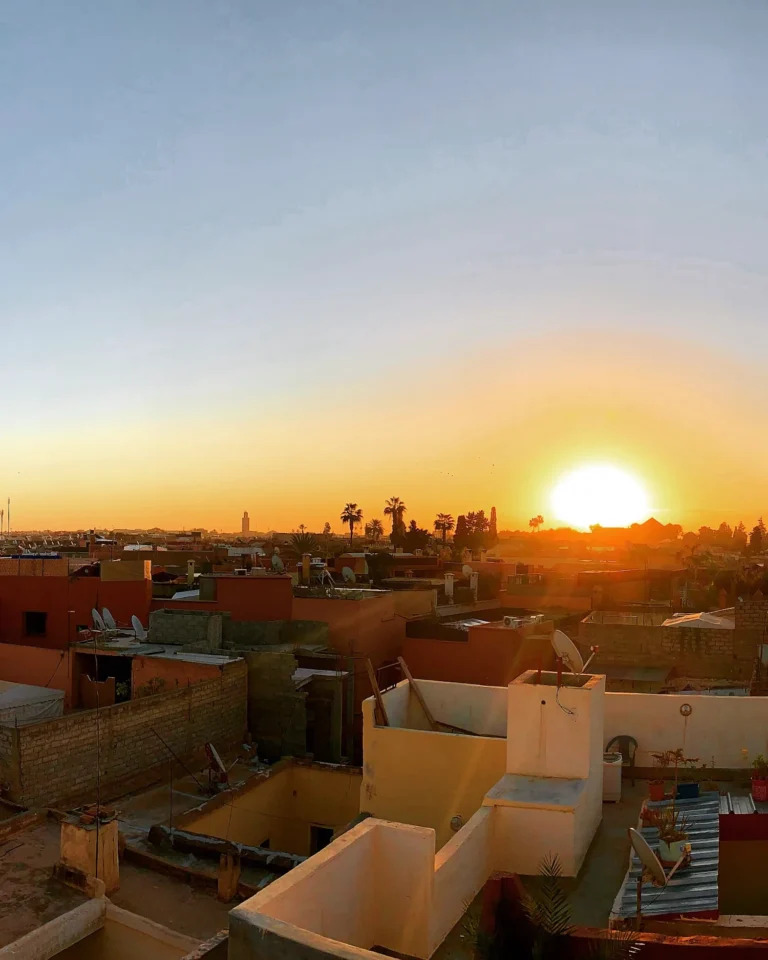 Sun setting as a large ball over Marrakech rooftops.