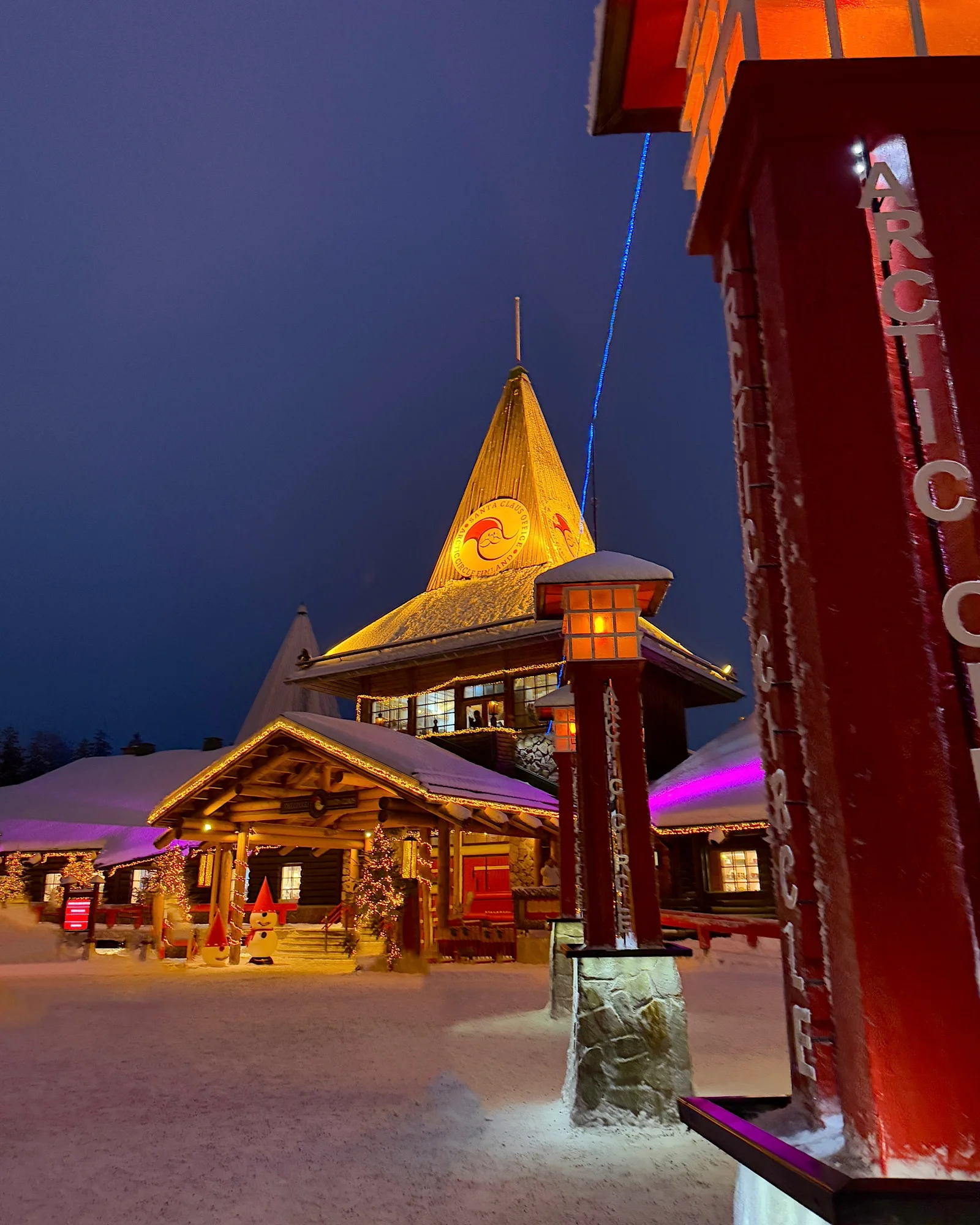 Panorama des beleuchteten Weihnachtsdorfes Rovaniemi am Abend mit festlicher Dekoration.