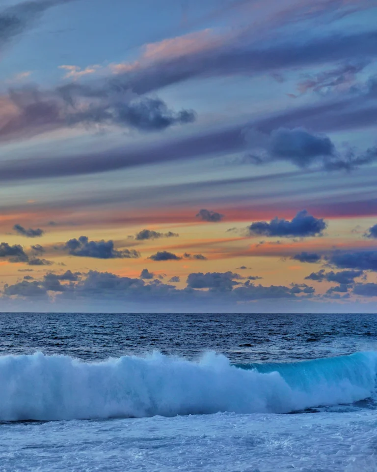 Dramatic pink sky during sunset over the waves at La Isleta, Lanzarote.