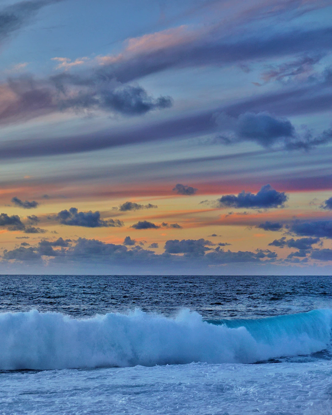 Dramatic pink sky during sunset over the waves at La Isleta, Lanzarote.