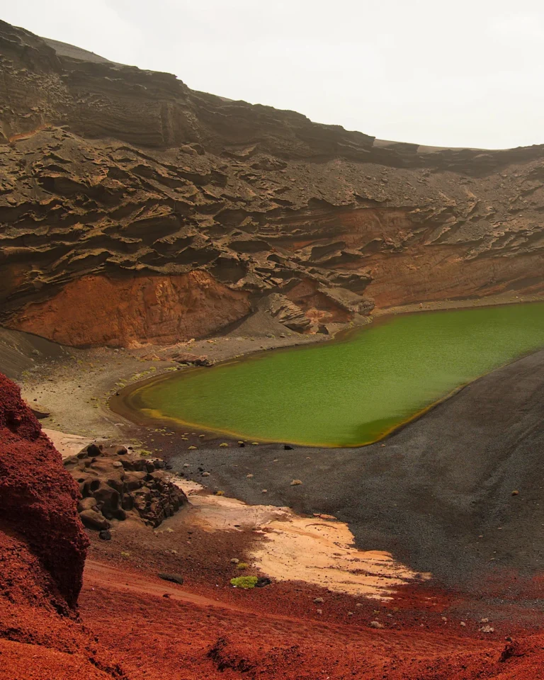 The green lagoon Lago Verde on the black volcanic beach of El Golfo, Lanzarote.